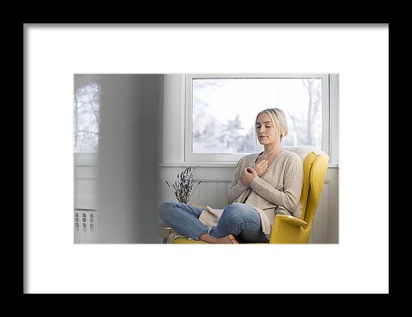Tranquility Framed Print featuring the photograph Woman meditating at home by Jamie Grill
