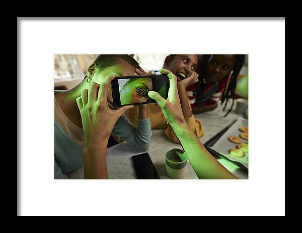 Cool Attitude Framed Print featuring the photograph Woman photographing female friend's eye on phone by Klaus Vedfelt
