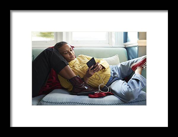 Internet Framed Print featuring the photograph Woman using phone while leaning on friend's leg by Klaus Vedfelt