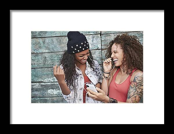 Cool Attitude Framed Print featuring the photograph Women listening to mp3 player on city street by Peathegee Inc