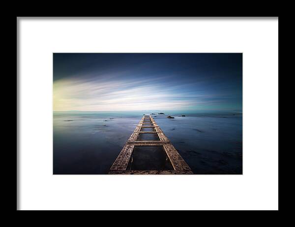 Sea Framed Print featuring the photograph Wooden pier remains in a blue sea. Long Exposure. by Stefano Orazzini