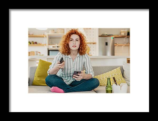 Internet Framed Print featuring the photograph Worried young woman is watching tv by blackCAT