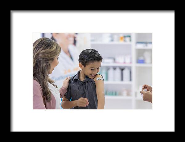 Relief Framed Print featuring the photograph Young boy receives bandage after vaccine by SDI Productions