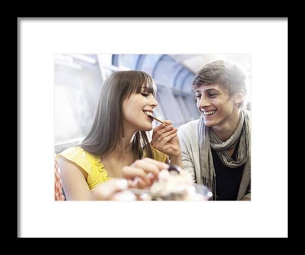 Young Men Framed Print featuring the photograph Young couple sharing ice cream by Oliver Rossi