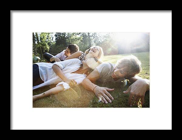 Young Men Framed Print featuring the photograph Young friends hanging out in a park by Oliver Rossi
