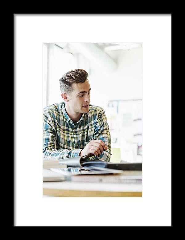 Young Men Framed Print featuring the photograph Young man sitting and studying in classroom by Kentaroo Tryman