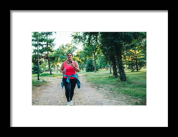 Recreational Pursuit Framed Print featuring the photograph Young overweight woman running by Urbazon