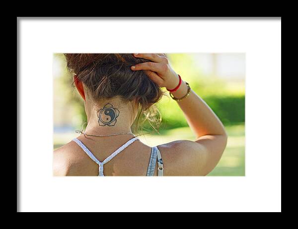 Human Arm Framed Print featuring the photograph Young woman back view showing tatoo by Rosmarie Wirz