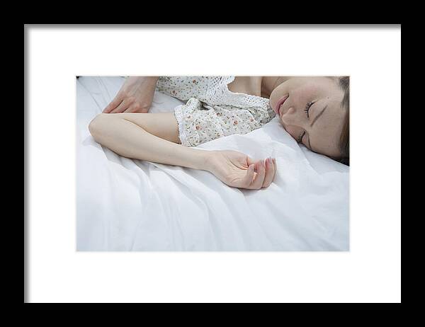 People Framed Print featuring the photograph Young woman sleeping on bed by Indeed
