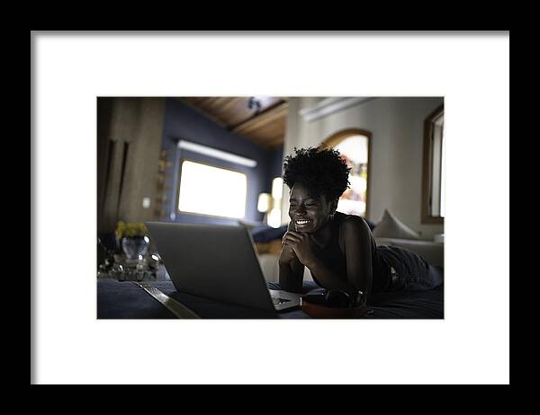 Internet Framed Print featuring the photograph Young women watching movie on a laptop at home by FG Trade
