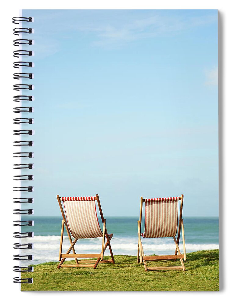 Grass Spiral Notebook featuring the photograph Deck Chairs On Coastline Facing Out To by Dougal Waters