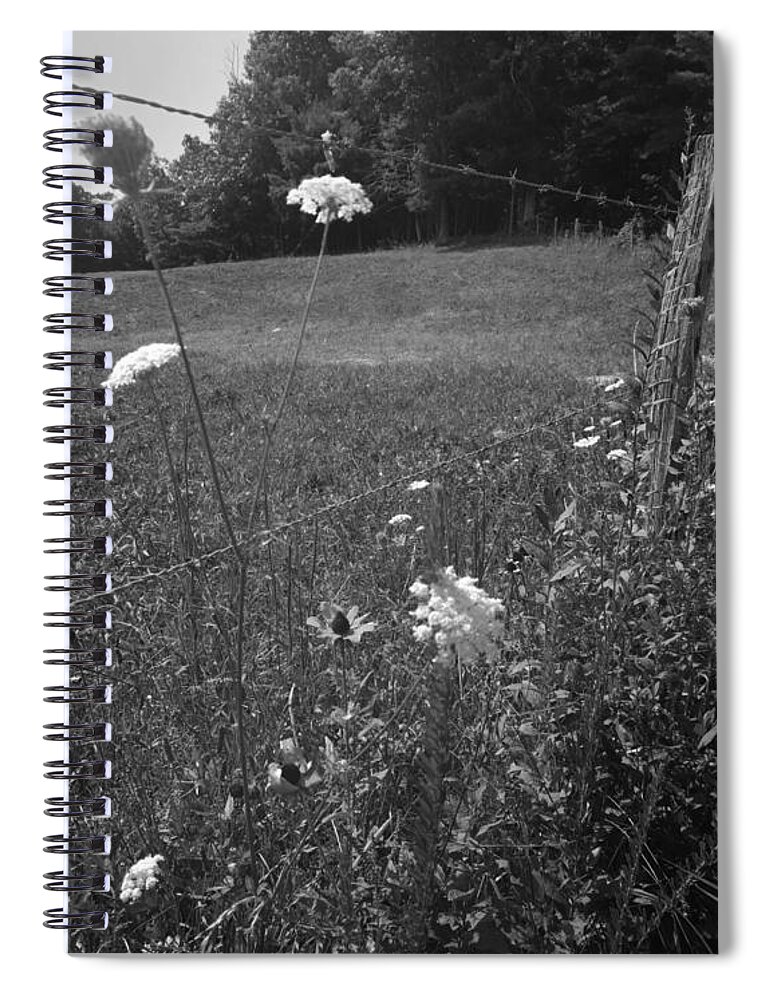 Kelly Hazel Spiral Notebook featuring the photograph Flowers by a Barbed Wire Fence by Kelly Hazel