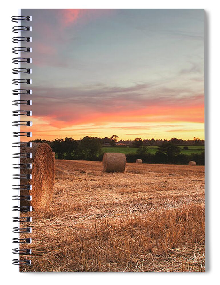Tranquility Spiral Notebook featuring the photograph Sunset Over Field Of Hay Bales by Verity E. Milligan