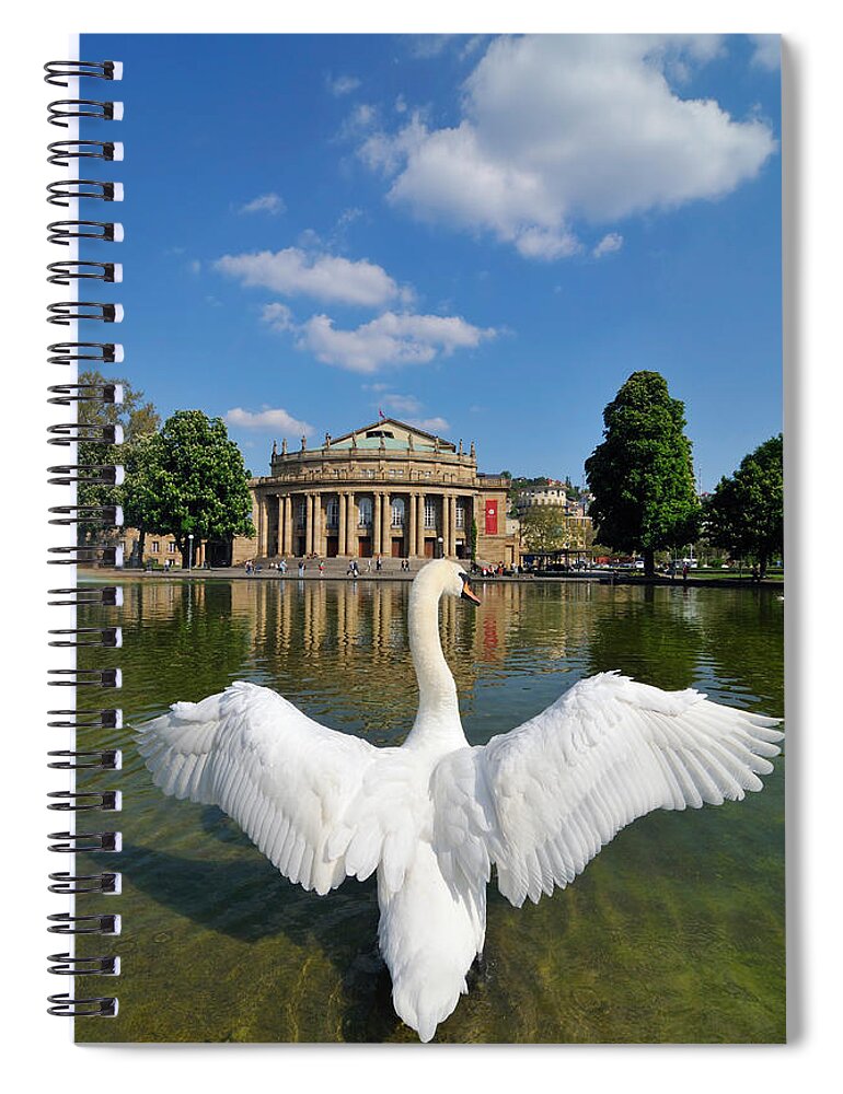 Swan Spiral Notebook featuring the photograph Swan spreads wings in front of State Theatre Stuttgart Germany by Matthias Hauser