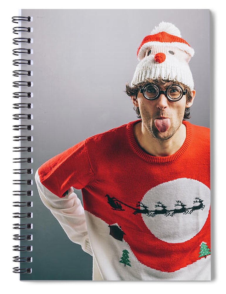 Man Spiral Notebook featuring the photograph Moody man in funny christmas clothes sticking out his tongue by Michal Bednarek