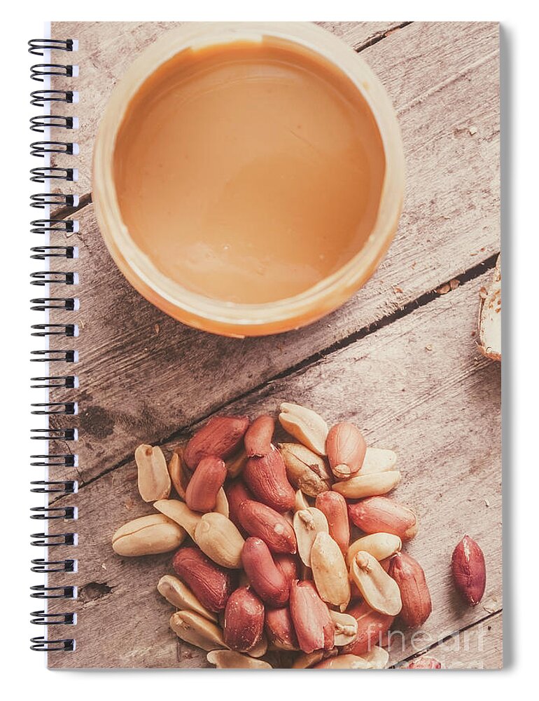 Peanuts Spiral Notebook featuring the photograph Peanut butter jar with peanuts on wooden surface by Jorgo Photography