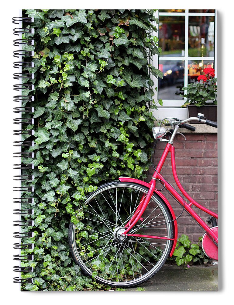 North Rhine Westphalia Spiral Notebook featuring the photograph A Red Bicycle Leaning Against A Wall by Carolin Voelker
