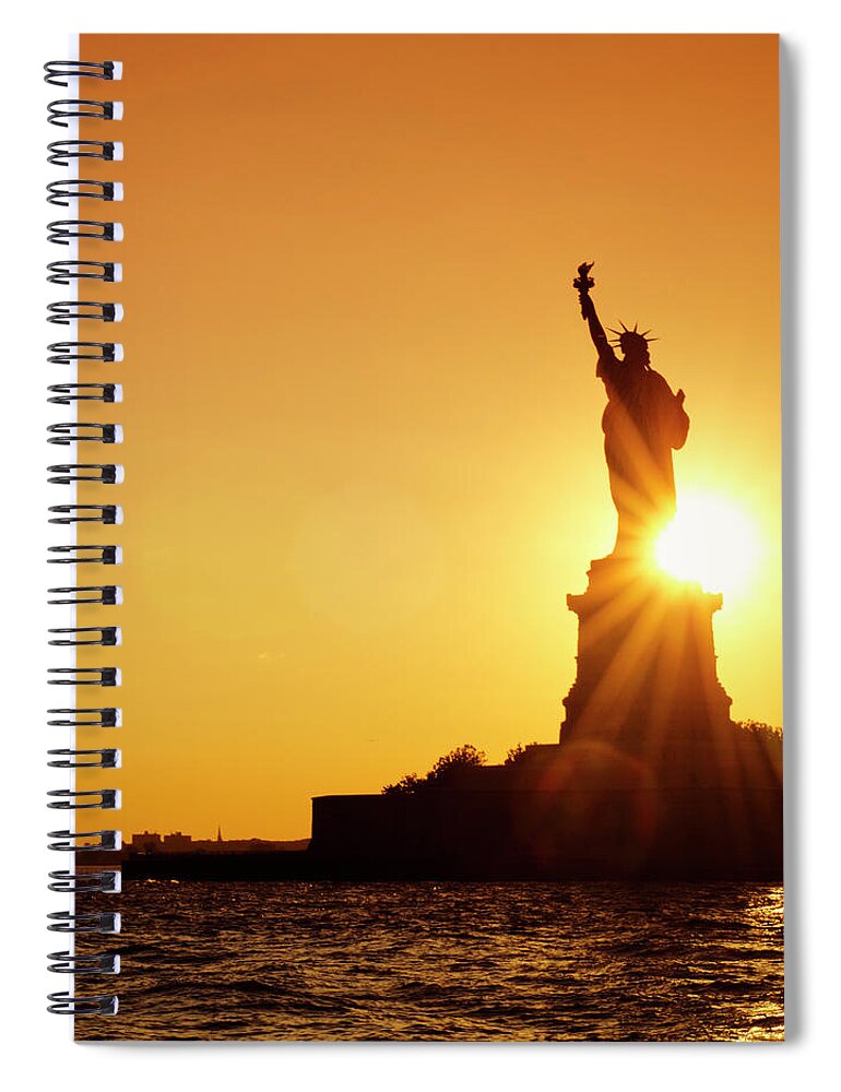 Orange Color Spiral Notebook featuring the photograph Statue Of Liberty Silhouetted At Dusk - by Franckreporter