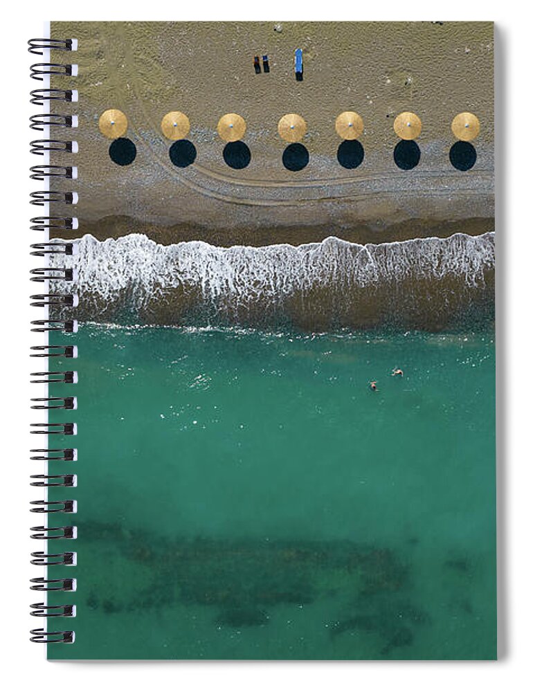  Beach Spiral Notebook featuring the photograph Aerial view from a flying drone of beach umbrellas in a row on a by Michalakis Ppalis