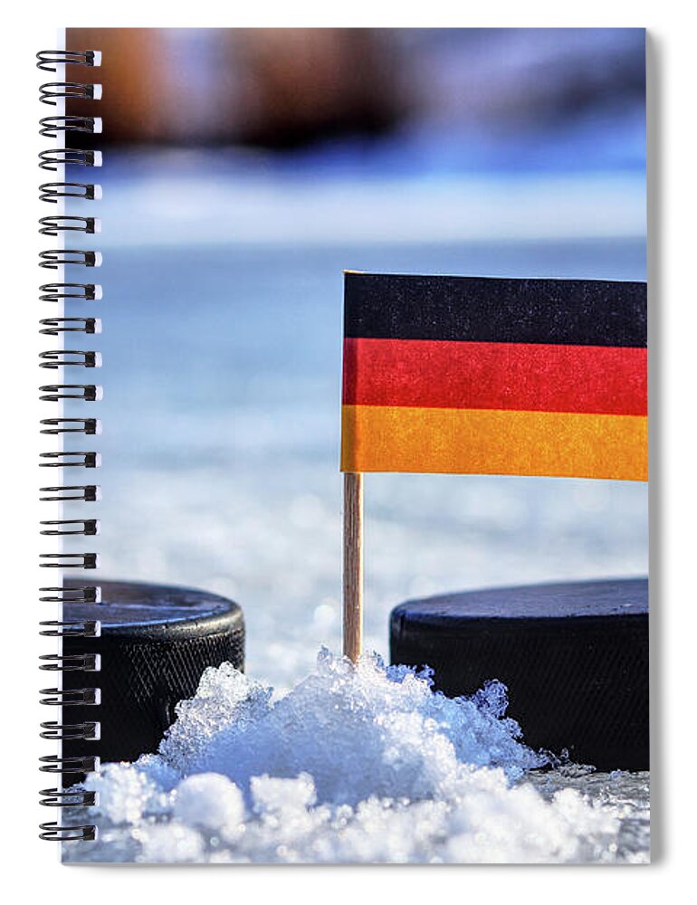 Germany Spiral Notebook featuring the photograph Germany flag on toothpick between two hockey pucks. Winter classic. Flag on frozen pond on unkempt ice. Traditional pucks for international matches. by Vaclav Sonnek