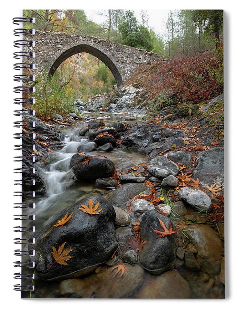 Autumn Spiral Notebook featuring the photograph Medieval stoned bridge with water flowing in the river in autumn. by Michalakis Ppalis