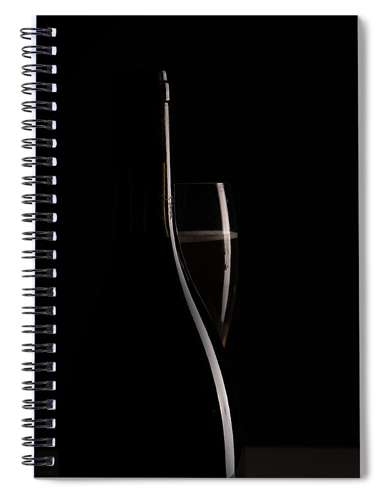 Red Wine Spiral Notebook featuring the photograph Red sparking wine on a wineglass and black wine bottle. by Michalakis Ppalis