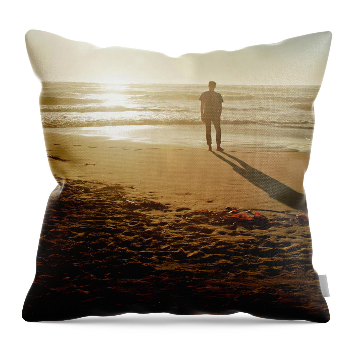 Tranquility Throw Pillow featuring the photograph A Silhouetted Figure Standing On A Beach by Tracy Packer Photography