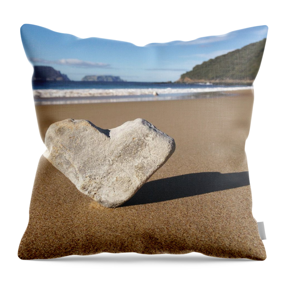 Water's Edge Throw Pillow featuring the photograph Heart Shaped Rock Sitting In Sand At by Jodie Griggs