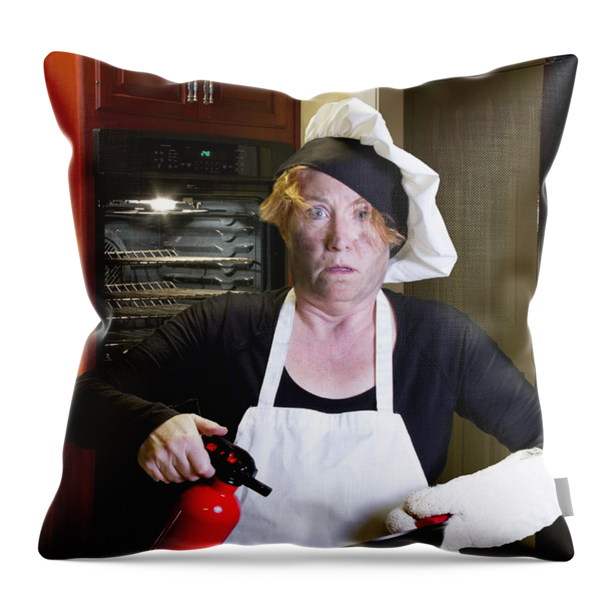 Burning Throw Pillow featuring the photograph Kichen disaster in apron with fire extinguisher and pan by Karen Foley