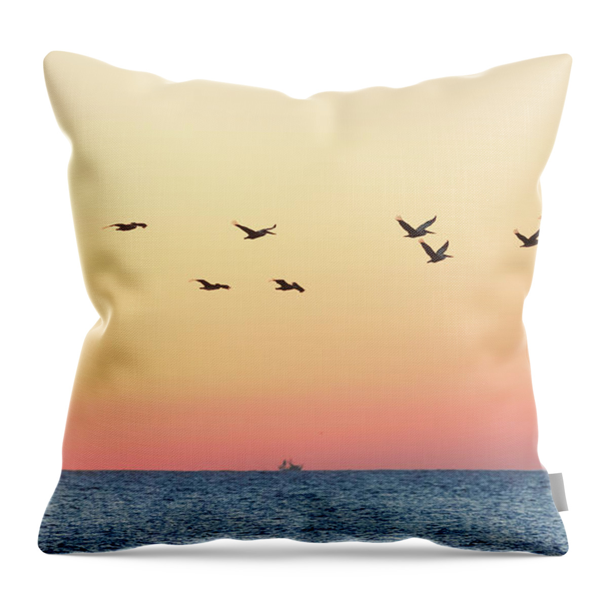Sunrise Throw Pillow featuring the photograph A Dozen Pelicans Flying over the Ocean by Robert Loe