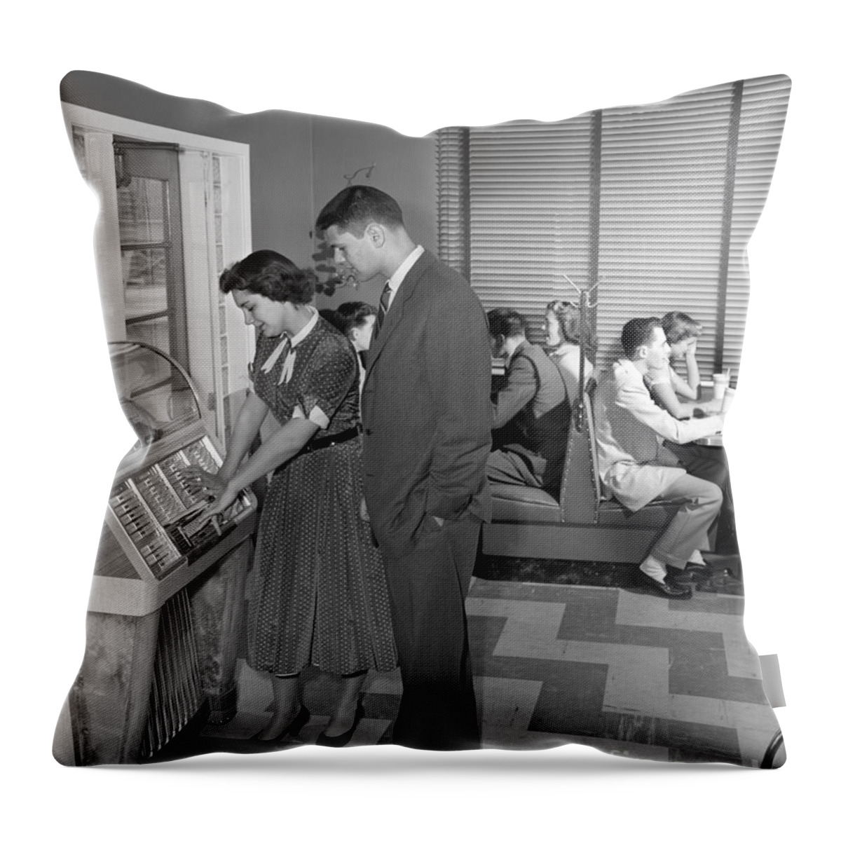 1950s Throw Pillow featuring the photograph Teen Couple Playing Jukebox, C. 1950s by H. Armstrong Roberts/ClassicStock