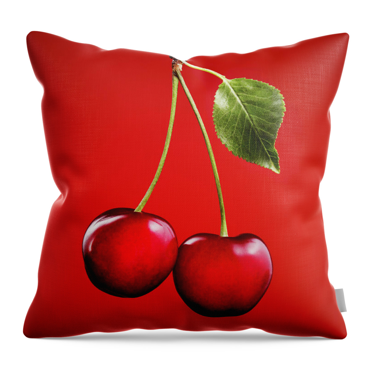 Cherry Throw Pillow featuring the photograph Cherries With Leaf On Red Background by Lauren Burke