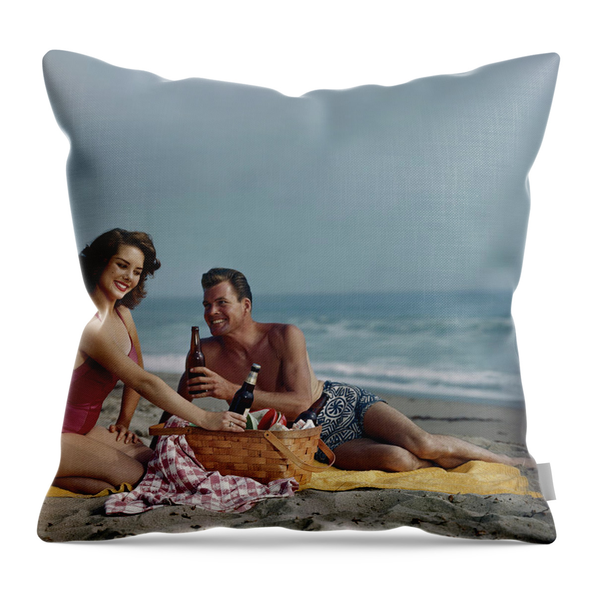 Heterosexual Couple Throw Pillow featuring the photograph Couple Sitting On Beach Holding Beer by Tom Kelley Archive
