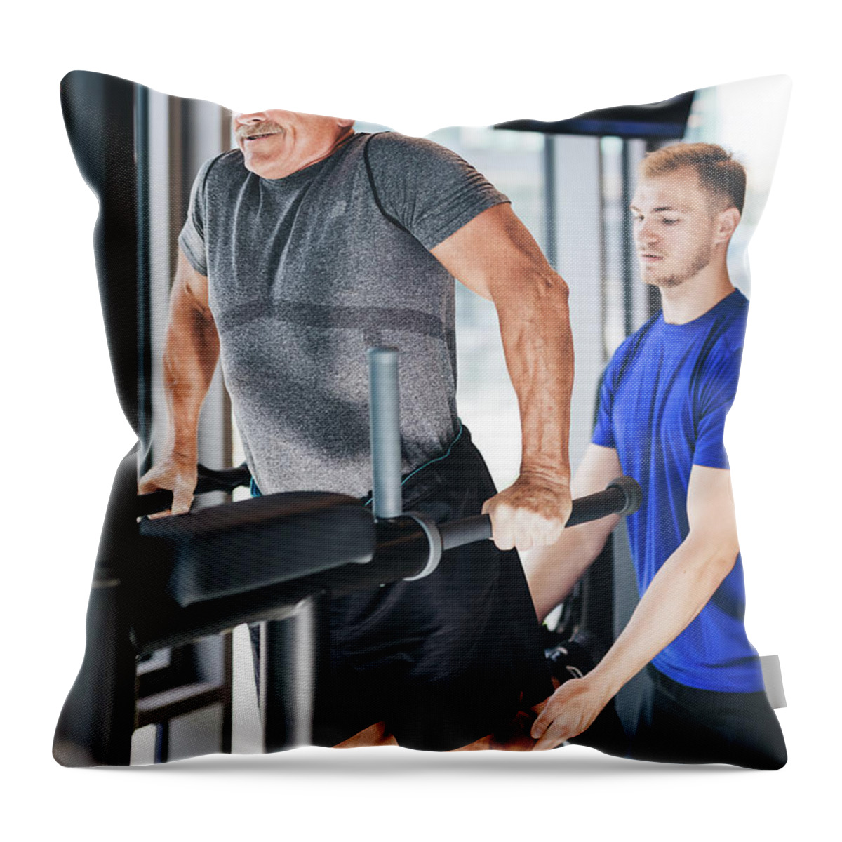 Man Throw Pillow featuring the photograph Gym instructor helping senior man at the gym. by Michal Bednarek