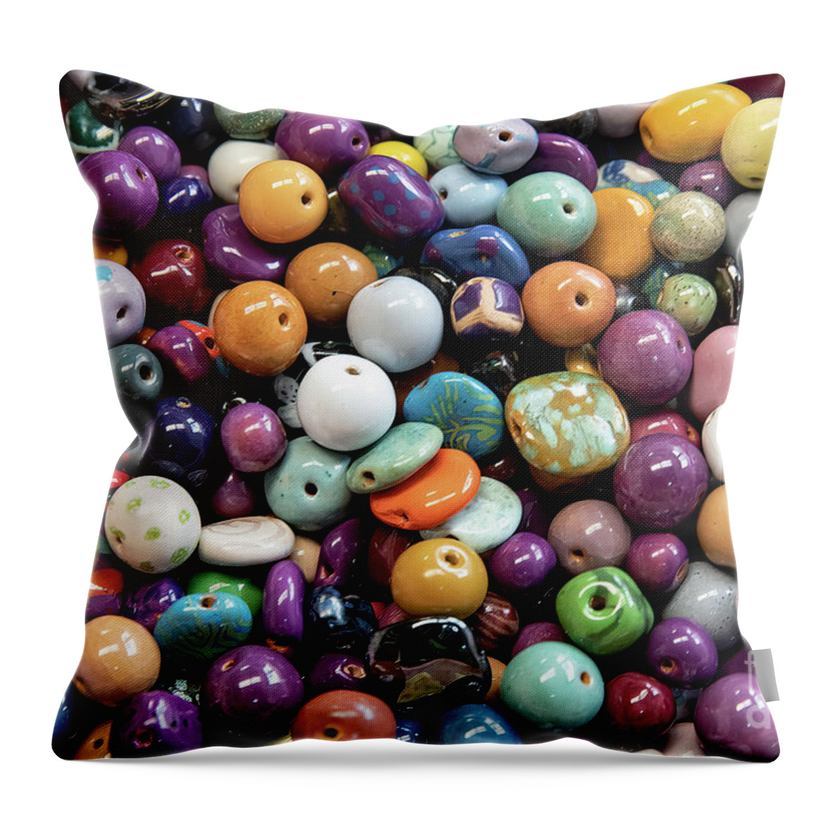 Bead Throw Pillow featuring the photograph A background of colourful ceramic glazed beads. Traditional African beads for ethnic jewelery and souvenirs. Overhead view by Jane Rix