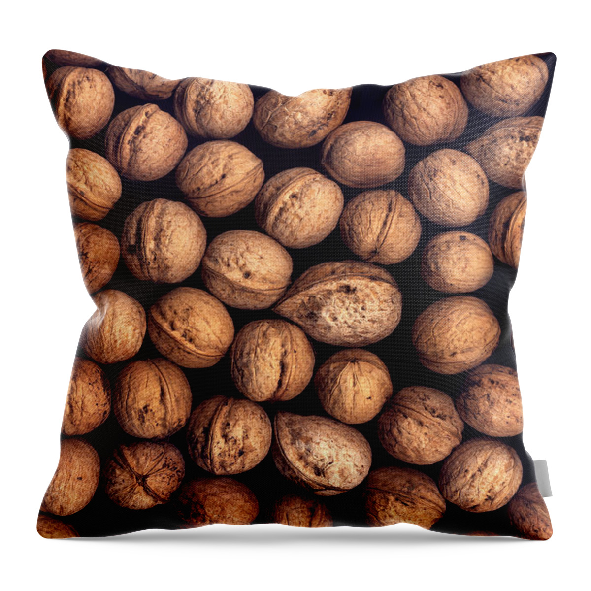 Nut Throw Pillow featuring the photograph Background of walnuts on a black background by Valentin Ivantsov
