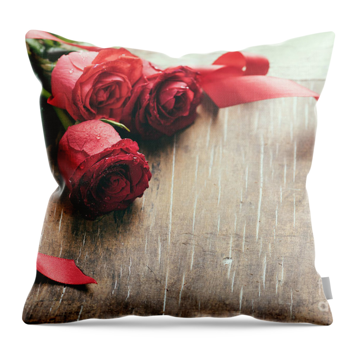 Roses Throw Pillow featuring the photograph Red roses with red ribbon on wooden table by Jelena Jovanovic