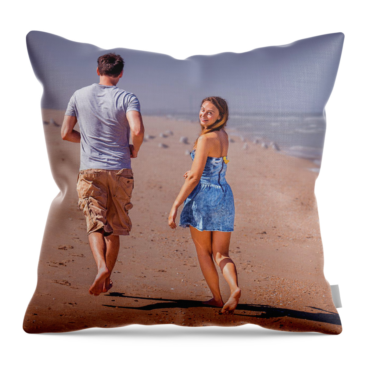 Young Throw Pillow featuring the photograph Young couple running on Sandy Hook Beach, New Jersey, USA. by Alexander Image