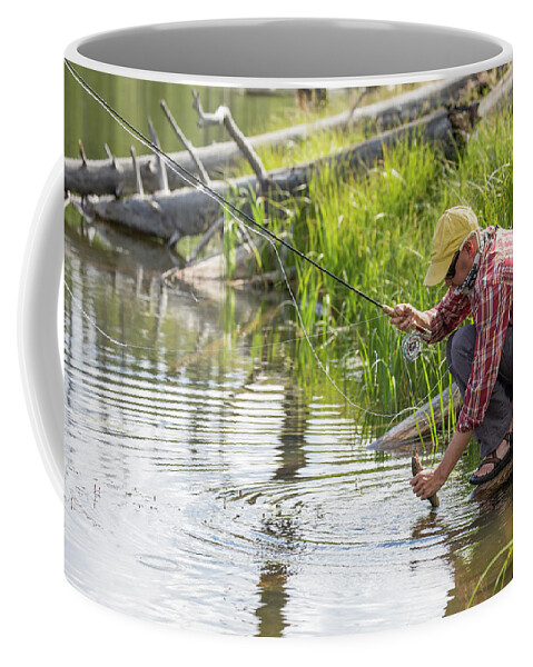 Holding Coffee Mug featuring the photograph A Fisherman Releases A Trout In A High #1 by Jess McGlothlin Media