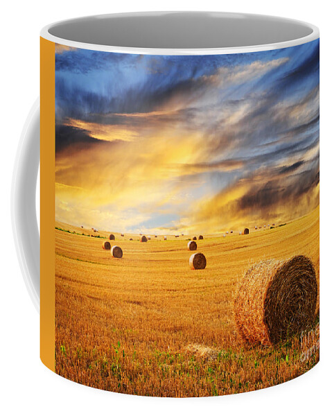 Farm Coffee Mug featuring the photograph Golden sunset over farm field with hay bales by Elena Elisseeva