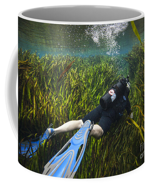 Scuba Diving Coffee Mug featuring the photograph A Scuba Diver Swims Through An by Michael Wood