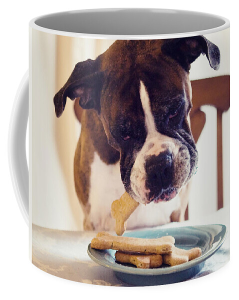 Boxer Coffee Mug featuring the photograph Dog eating biscuits at table by Stephanie McDowell