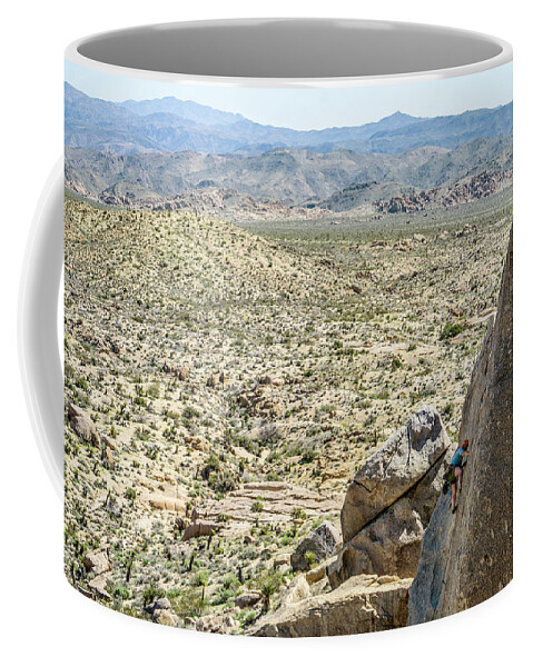 Conquering Adversity Coffee Mug featuring the photograph Man Climbing Rock Wall In Joshua Tree by Bennett Barthelemy