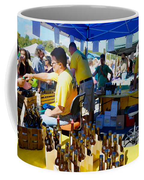 Hudson Coffee Mug featuring the painting A vendor at the Garlic Fest offers garlic vinegar and olive oil for sale by Jeelan Clark