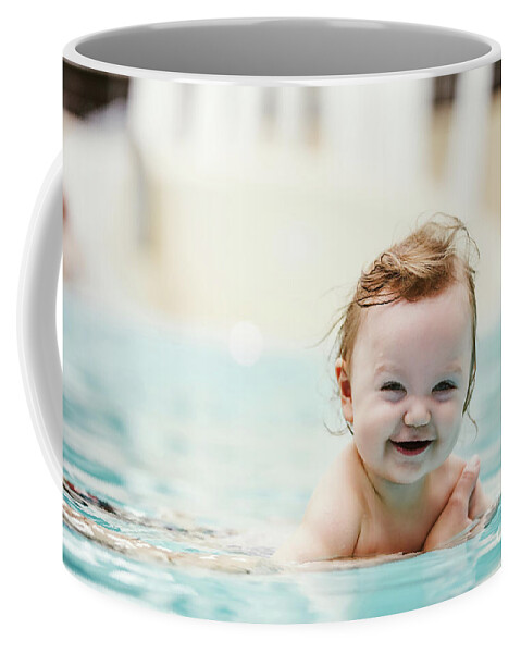 Girl Coffee Mug featuring the photograph Baby girl smiling and swimming in water. by Michal Bednarek