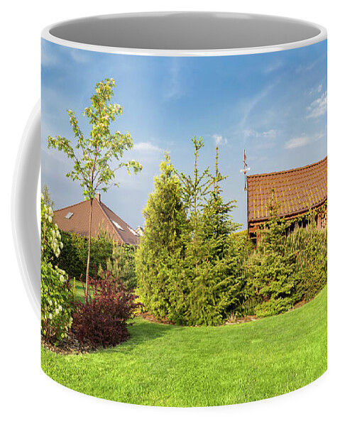 Garden Coffee Mug featuring the photograph Backyard of a family house. Landscaped garden with green mown grass, wood shelter. by Michal Bednarek