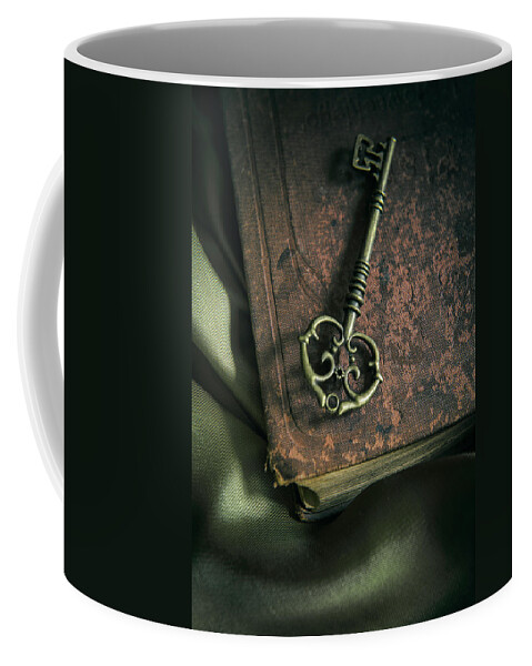 Key Coffee Mug featuring the photograph Brass ornamented key on old brown book by Jaroslaw Blaminsky