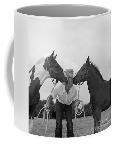 Adult Coffee Mug featuring the photograph Cowboy Between Two Horses, C.1960s by B. Taylor/ClassicStock