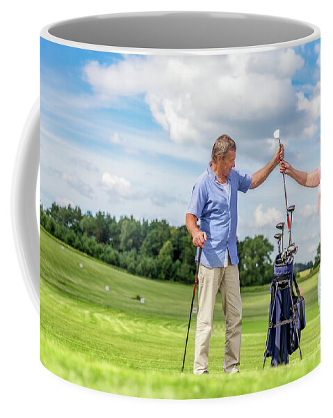 Golf Coffee Mug featuring the photograph Senior couple choosing equipment for a golf game. by Michal Bednarek