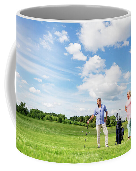 Golf Coffee Mug featuring the photograph Senior couple enjoying golf game. by Michal Bednarek